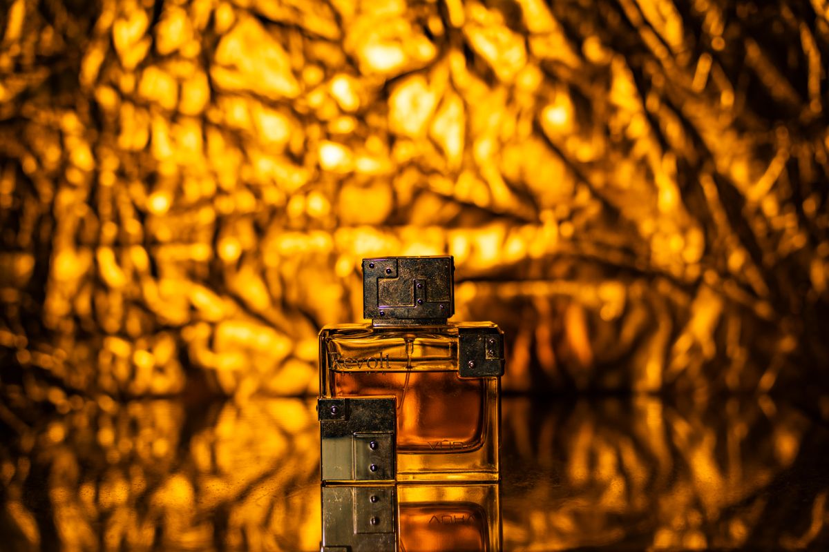Amber rectangular perfume bottle with metal block cap in golden light