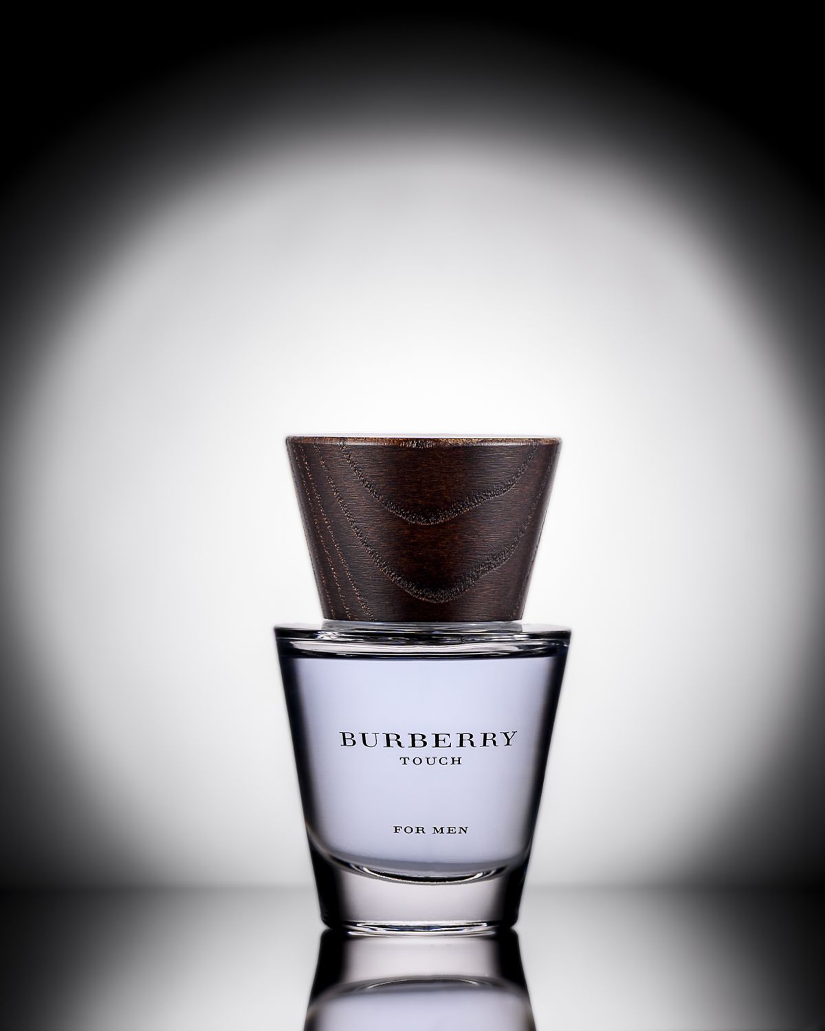 Burberry Touch perfume bottle with dark textured cap under spotlight