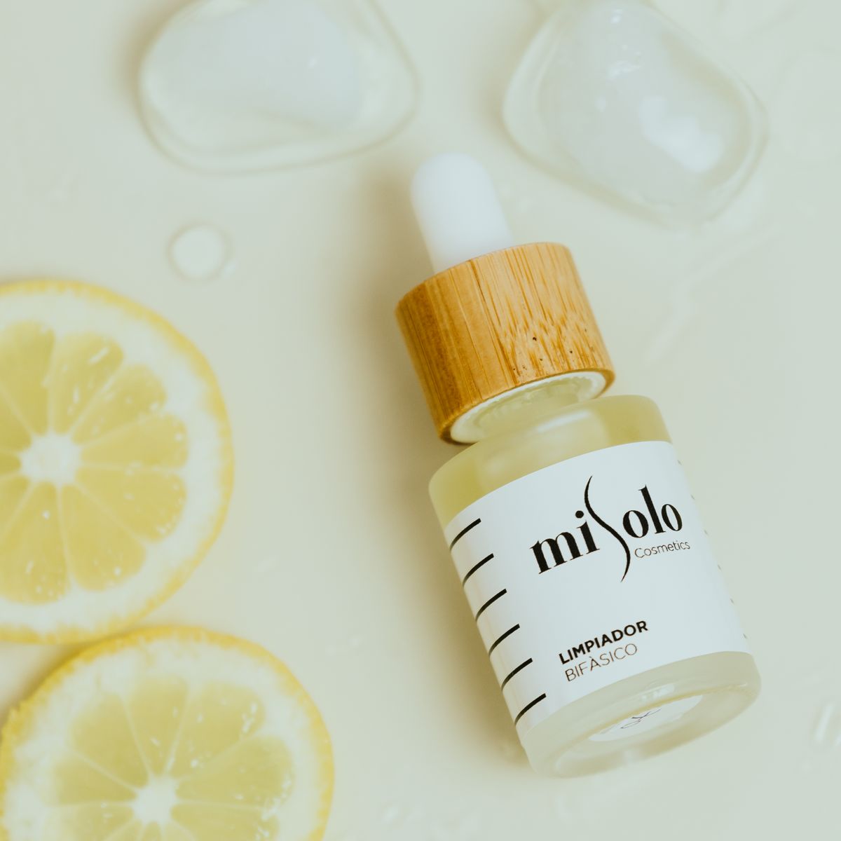 Dropper bottle with a wood cap beside sliced lemons